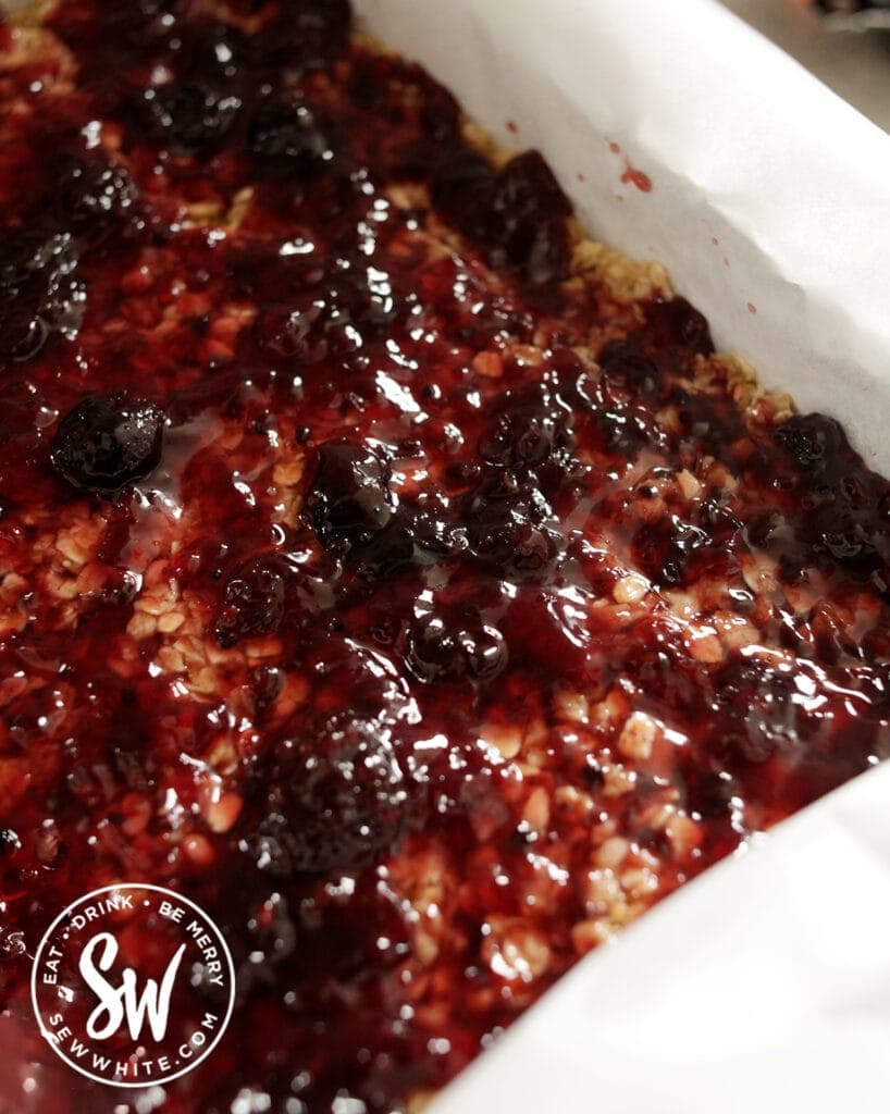 jam being smeared over the flapjack base