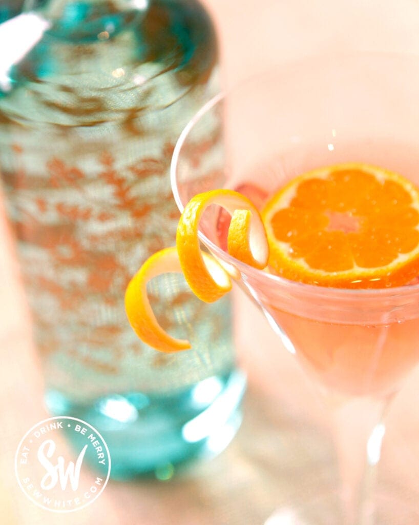 clementine cocktail in a cocktail glass with orange segment as decorations