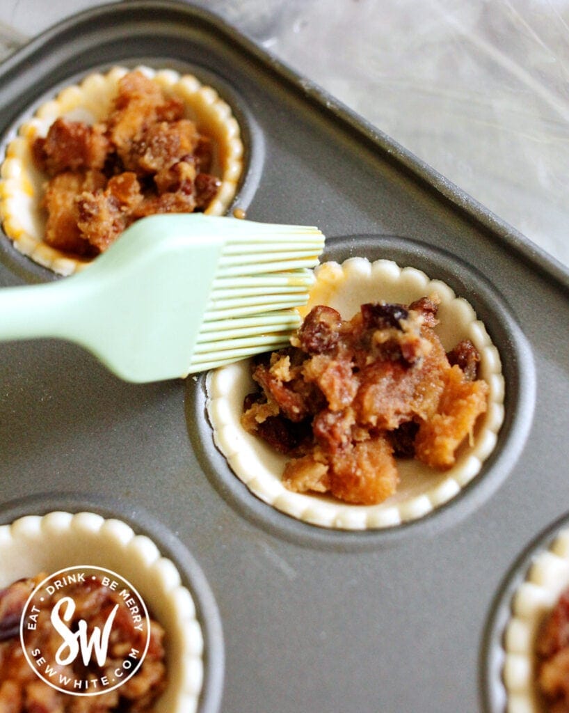 egg washing the shortcrust pastry with the mince pies