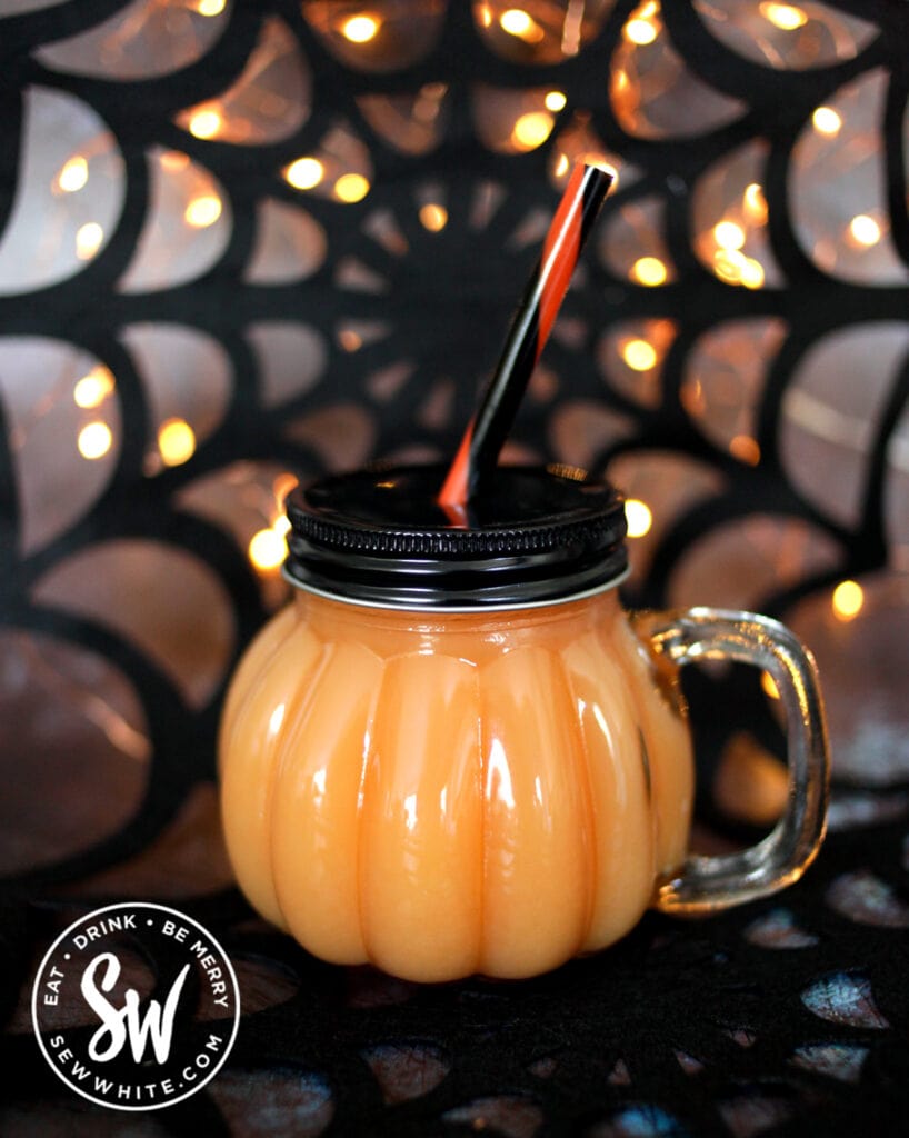 bright orange Vodka Halloween Cocktail in a pumpkin shaped glass