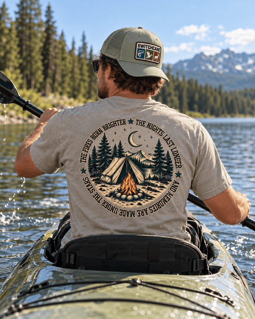 A man wearing a Switchcane Camping shirt canoeing