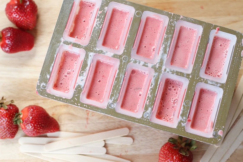 Keep cool this summer with these healthy Strawberries and Cream Popsicles.  Kids young and old will love this healthy summer snack recipe. These strawberry frozen treats won't last long. #popsicles #healthypopsicles #strawberrypopsicles #popsiclerecipe