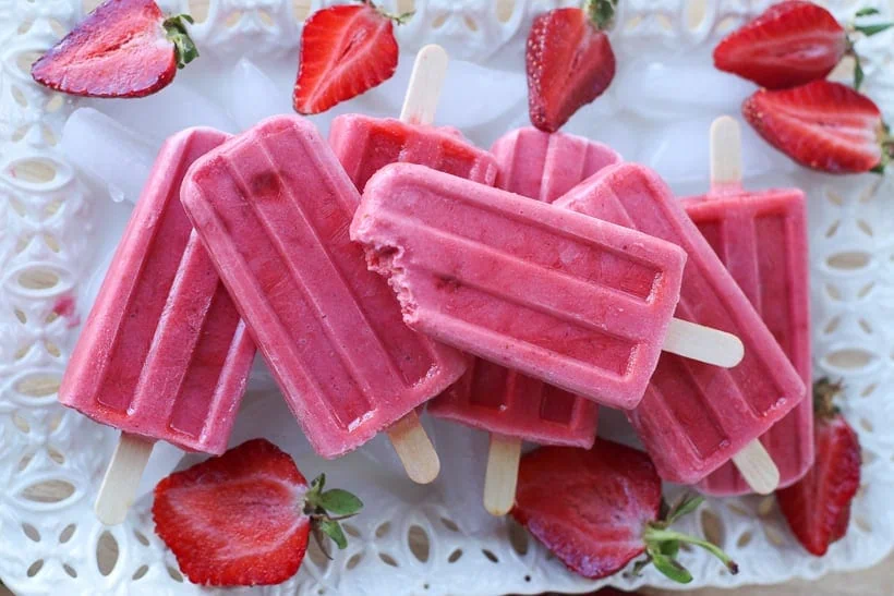 Keep cool this summer with these healthy Strawberries and Cream Popsicles.  Kids young and old will love this healthy summer snack recipe. These strawberry frozen treats won't last long. #popsicles #healthypopsicles #strawberrypopsicles #popsiclerecipe