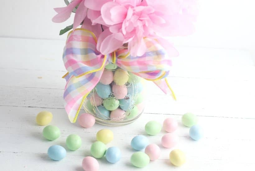 Add a touch of spring to your dining table. This easy Easter Candy Mason Jar Flower Vase is so easy to create. Grab so Easter candy and a mason jar and start crafting. You can make this easy holiday craft in just minutes. #eastercraft #holidaycraft