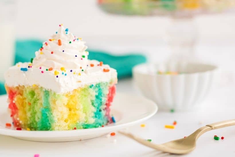 Make a colorful, moist, and utterly delicious cake within minutes with this Rainbow Poke Cake recipe. It is full of flavor and plenty of fun colors, including shades of pink, blue, and yellow!