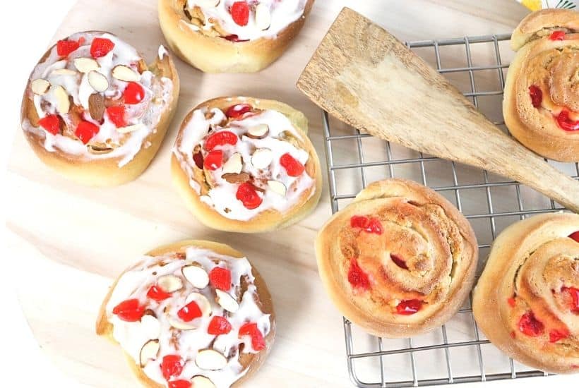 If you love eating baked goods for breakfast, try this Swedish Breakfast Rolls Recipe. These rolls are sweet, soft, fluffy, and perfect to eat for a quick grab and go breakfast. This easy Swedish breakfast bun recipe is consists of a sweet dough flavored with cardamon. Almonds and cherries are added and the sweet rolls are topped with a delicious icing glaze.