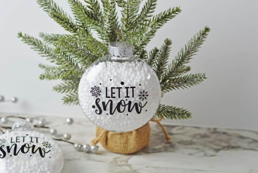 Who says you need the most expensive ornaments to make your Christmas tree look amazing? Learn how to easily create the most beautiful Let It Snow Ornament to hang on the tree or give as a gift. This DIY Ornament is an easy holiday Cricut Craft Idea. It is a great homemade Christmas gift craft idea.