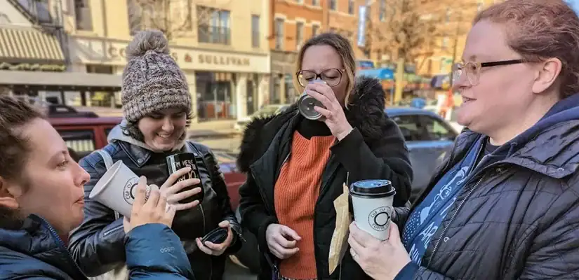 The Radio Free Bay Ridge podcast team, and friends, smiling and drinking coffee outside Cup of Joe Coffee Co.