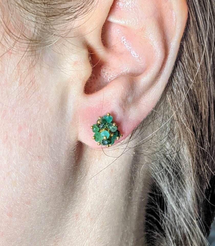 Close-up of a model wearing a pair of emerald beaded stud earrings