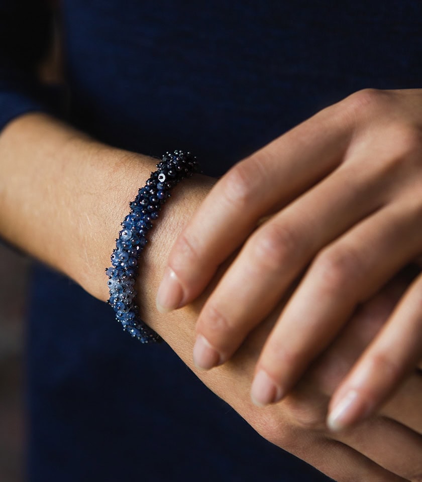 Close up of a woman's hands wearing a sapphire bracelet