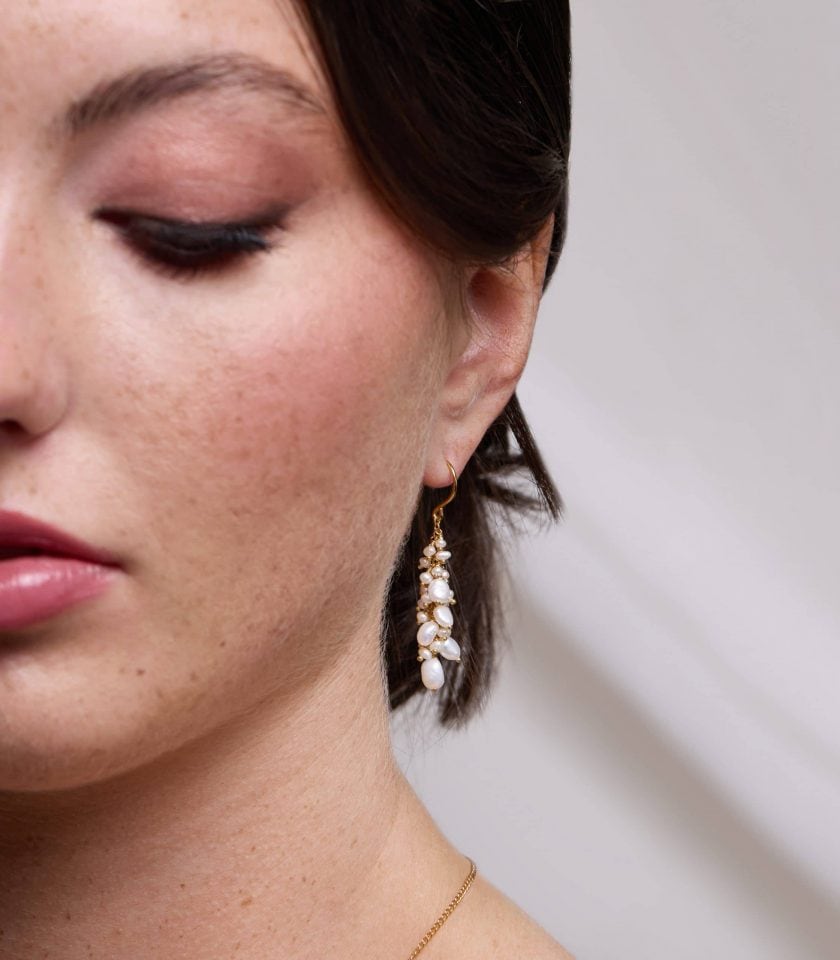 pearl cluster drop earrings worn by a model