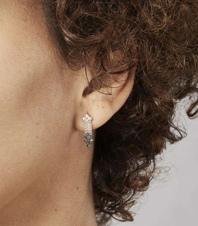 Photo of close up of models ear, wearing diamond and silver stud earring