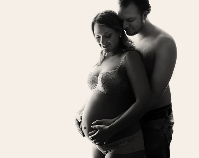 Kvinne og mann som knytter seg intime under gravidfotografering, gravidfoto av par, naturlig graviditetsbilder, kjærlighet mellom foreldre og baby, vakker graviditet, profesjonell gravidfotograf i Norge.