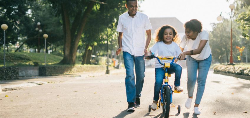parents and kid on a bike
