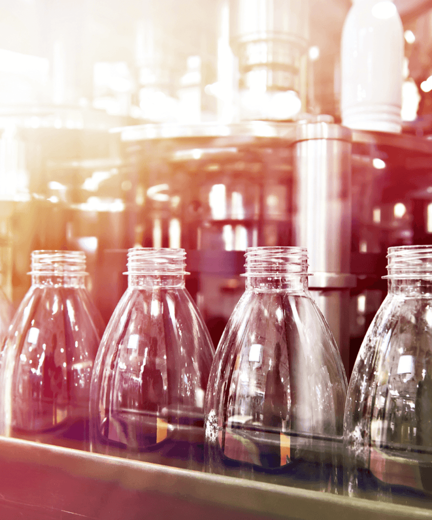 Rows of bottles lined up in a factory for quality testing.