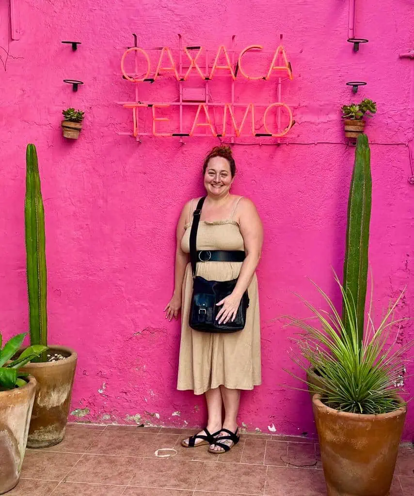 woman in front of a pin wall and I love Oaxaca sign (Oaxaca te amo)