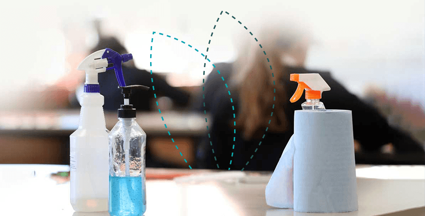 Cleaning supplies on a table in a business setting, ensuring superior hygiene with disinfectant sprays.