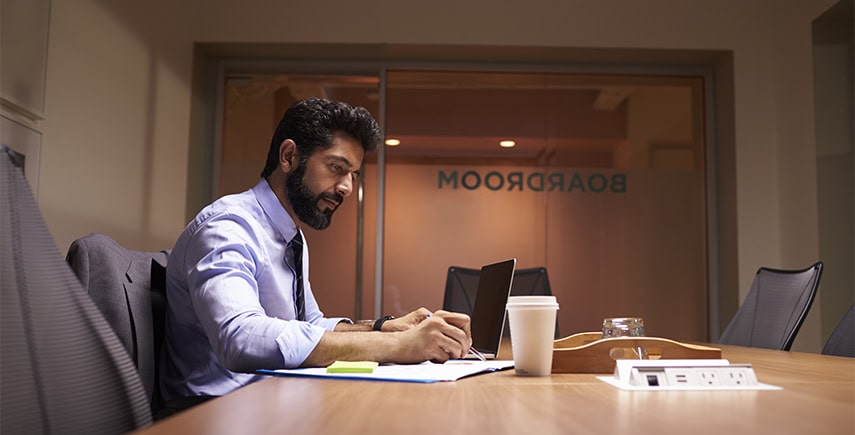 Professional working in a boardroom, maintaining personal hygiene with a tidy appearance and clean workspace.