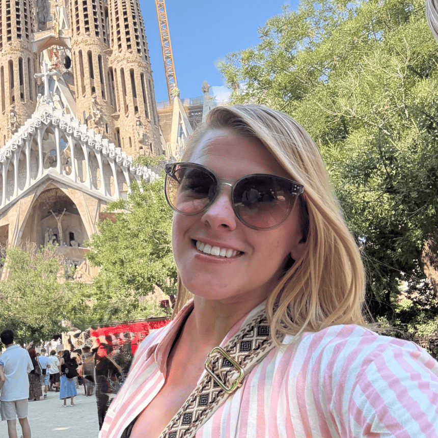 Woman smiling in front of Sagrada Familia in Barcelona, Spain.