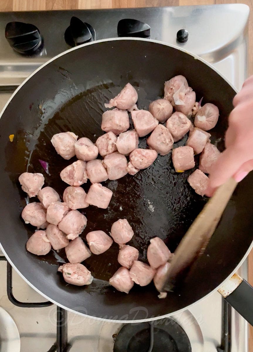uncooked sausages in pan.