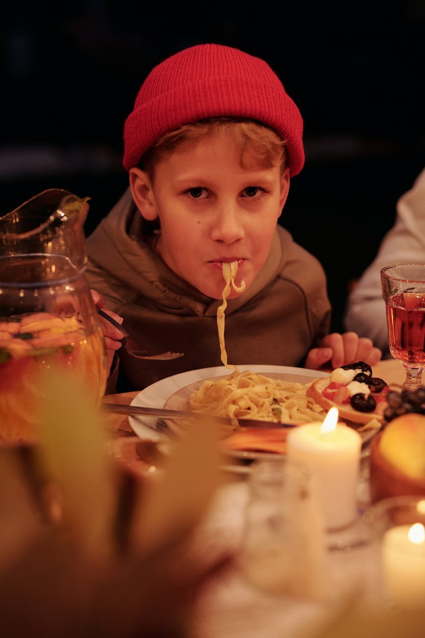 boy having pasta during family dinner