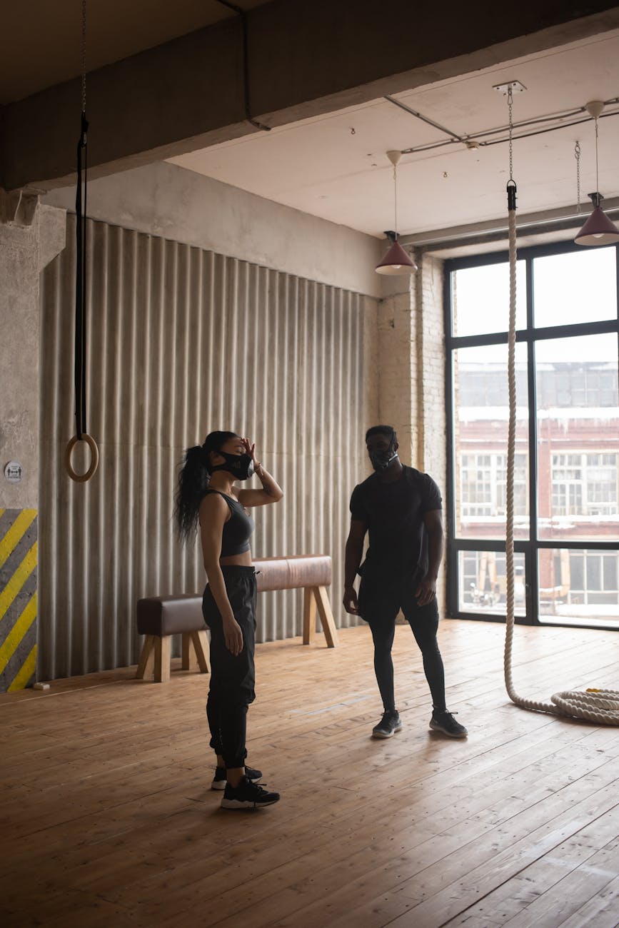 anonymous ethnic sportspeople having break from workout in gym