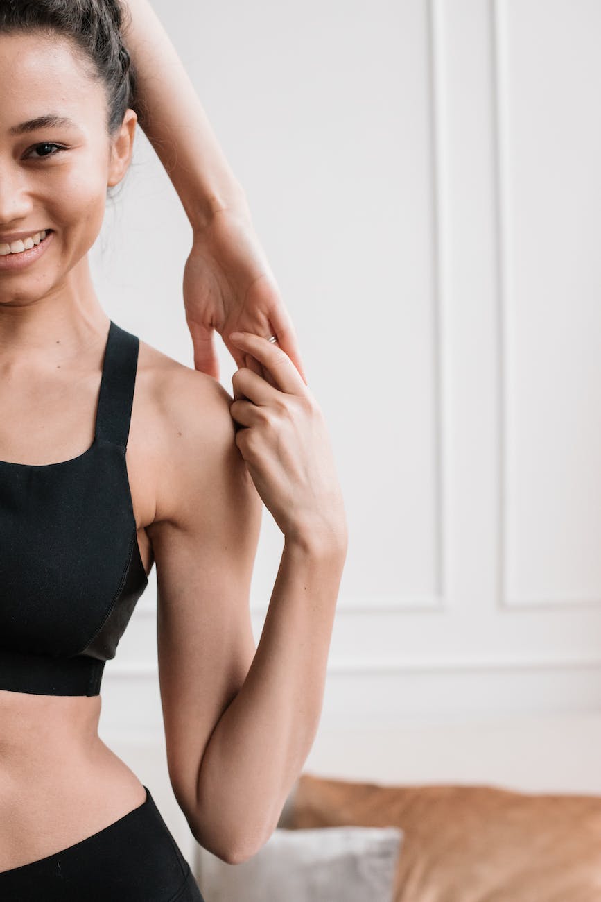 Woman in a tank top stretching her arm