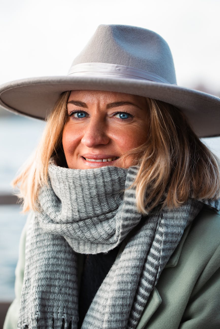 smiling woman in stylish hat and scarf outdoors