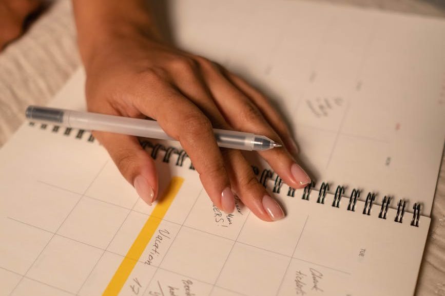 person writing on an amazon find to navigate a low capacity day - a planner