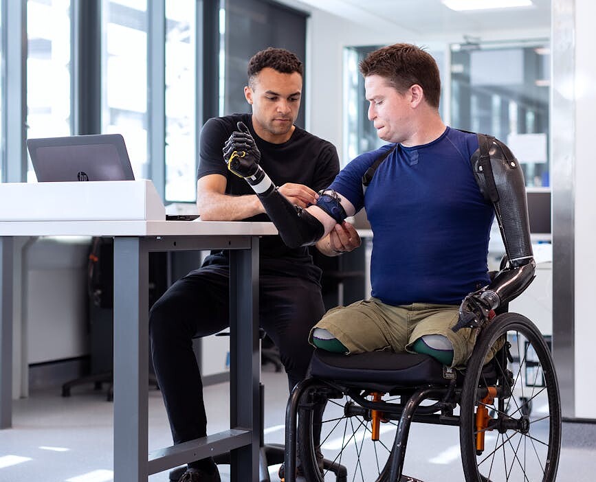 engineer fitting prosthetic arm