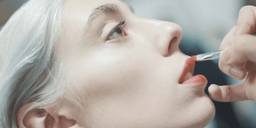 Fashion film and event video production showcasing behind-the-scenes makeup application backstage at a runway show.