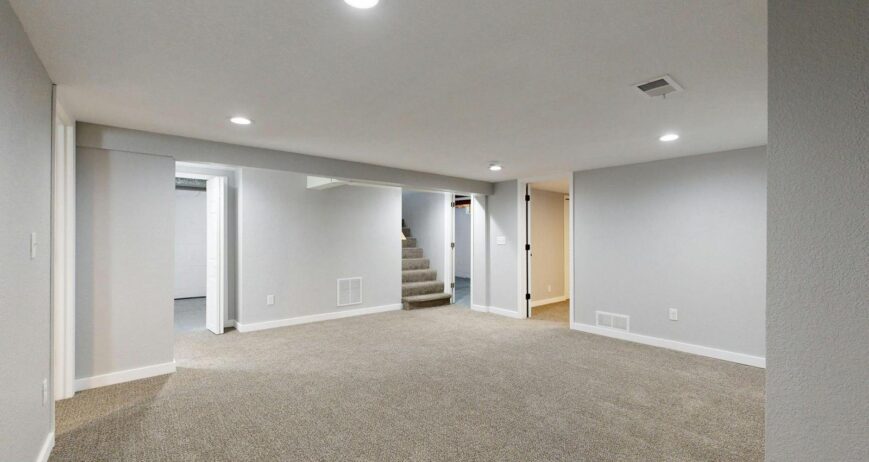 Legal Basement Suite cost in Ontario - Spacious modern basement with neutral design and carpet flooring, perfect for renovati