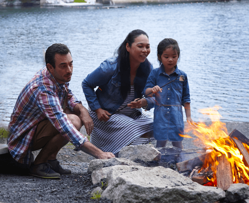 Small Family Sitting Near a Campfire