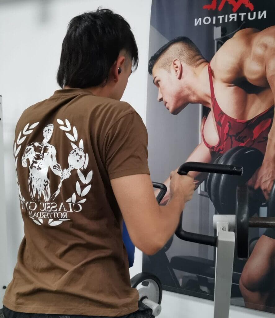 Beginnende sporter met gymlogo tshirt traint rowing panatta, voor een motiverende poster van een bodybuilder. Worrd ook lid en kies voor incasso gemak.