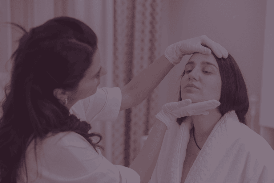 Dermatóloga examinando la piel del rostro de una paciente