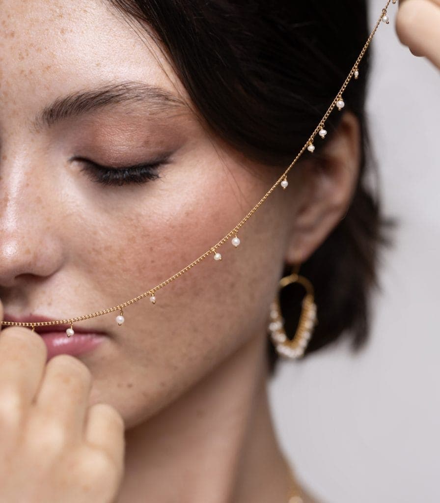 scattered pearl necklace held by a model