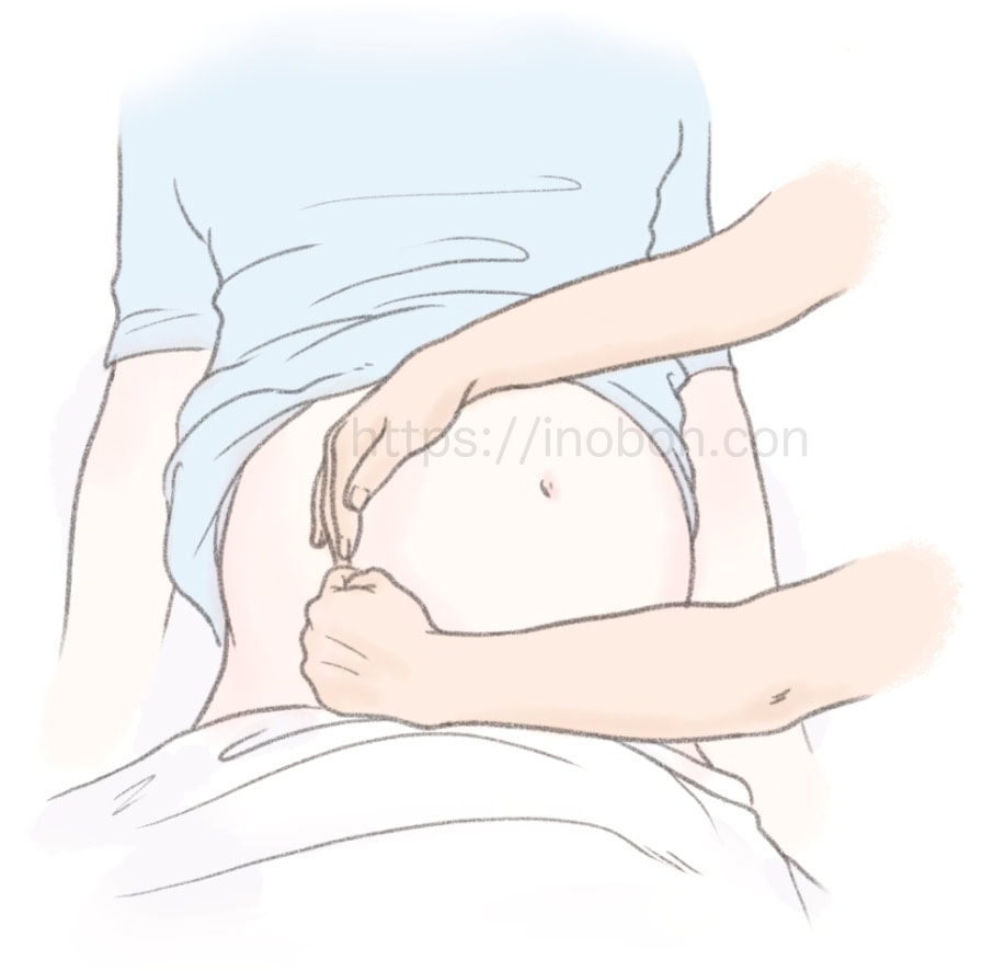 助産師が妊婦の腹部に手を当てている
