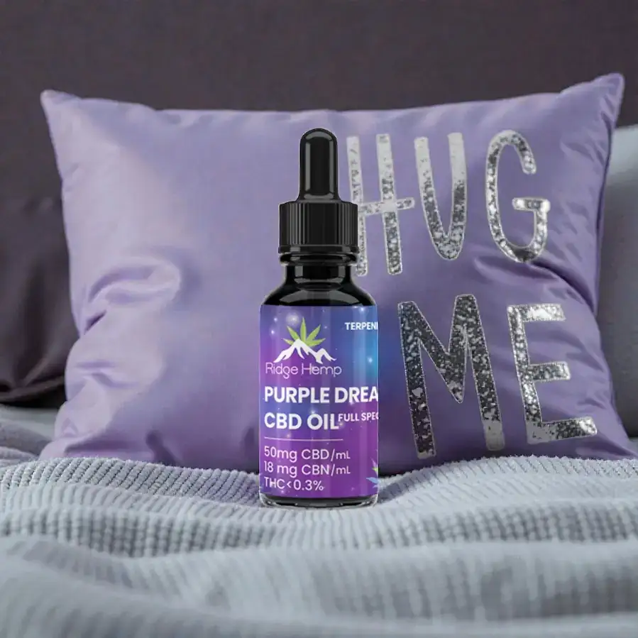 a bottle with purple dreams max CBD/CBN sublingual oil on a pillow