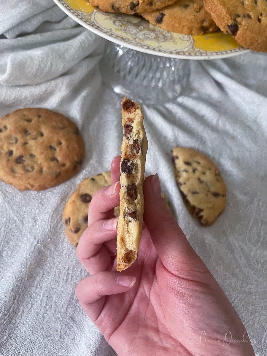 close up of inside of broken cookie, chocolate chips visible.