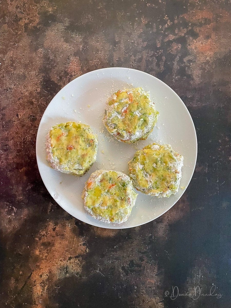 unbaked bubble and squeak patties on a plate.