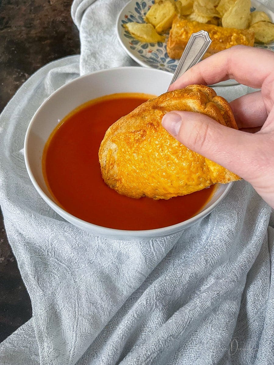 toastie being dipped into tomato soup.