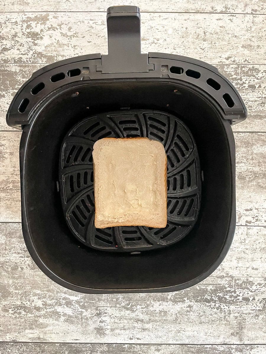 buttered bread in air fryer basket.