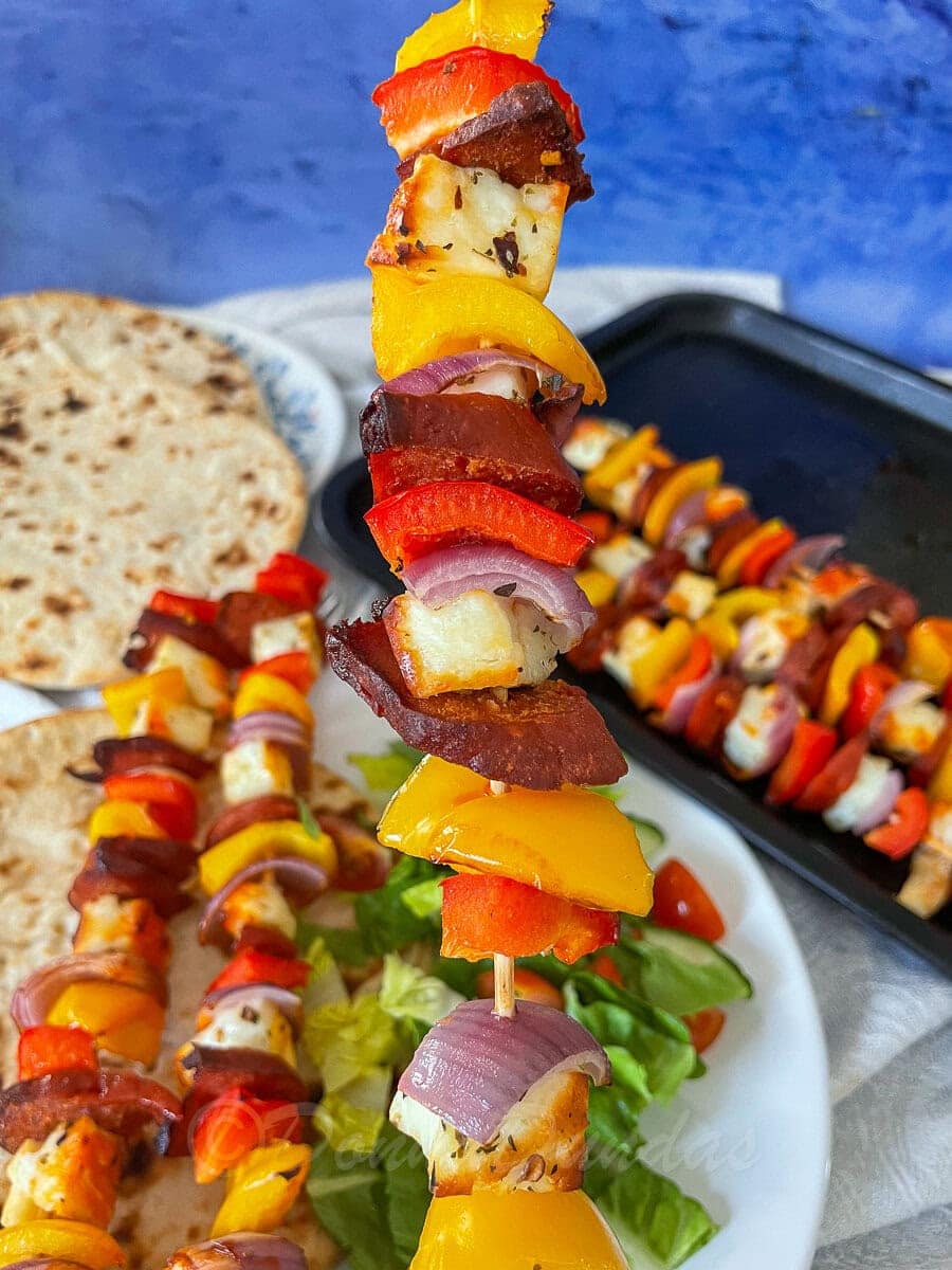 close up of halloumi, chorizo, peppers and onions on skewer.