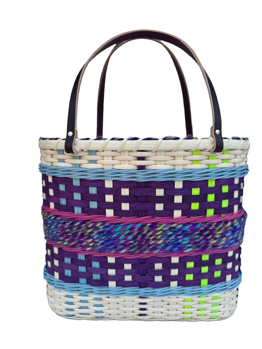 Purple tote bag with long dark handles and yarn and colored reed