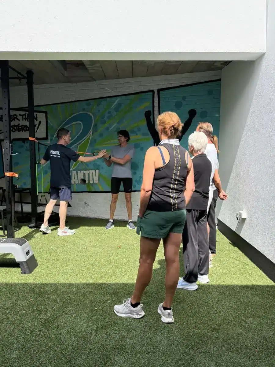 Een trainer begeleidt een groep 50-plussers tijdens een Healthy Ageing-oefening bij ProAktiv. in Haacht