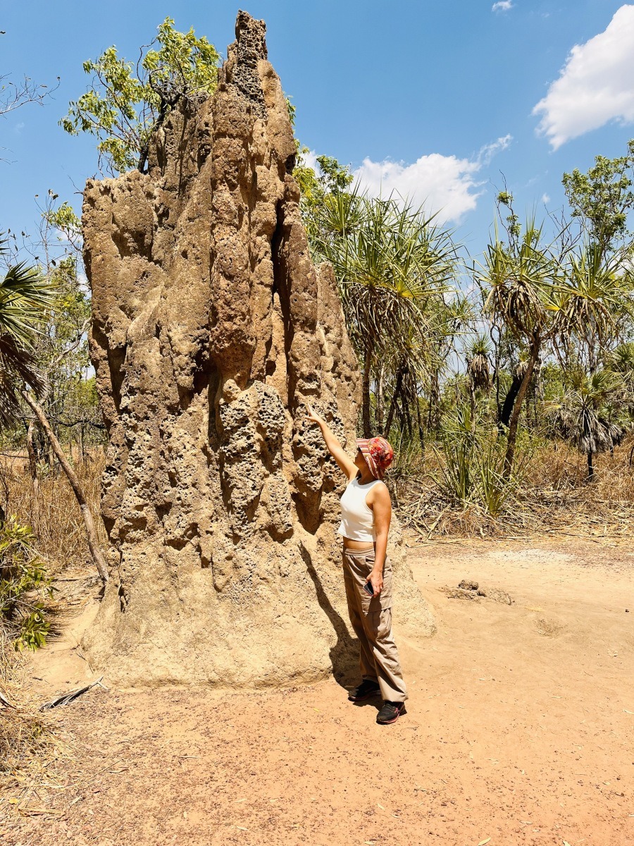 Woman standing next to a giant termite mound in Litchfield