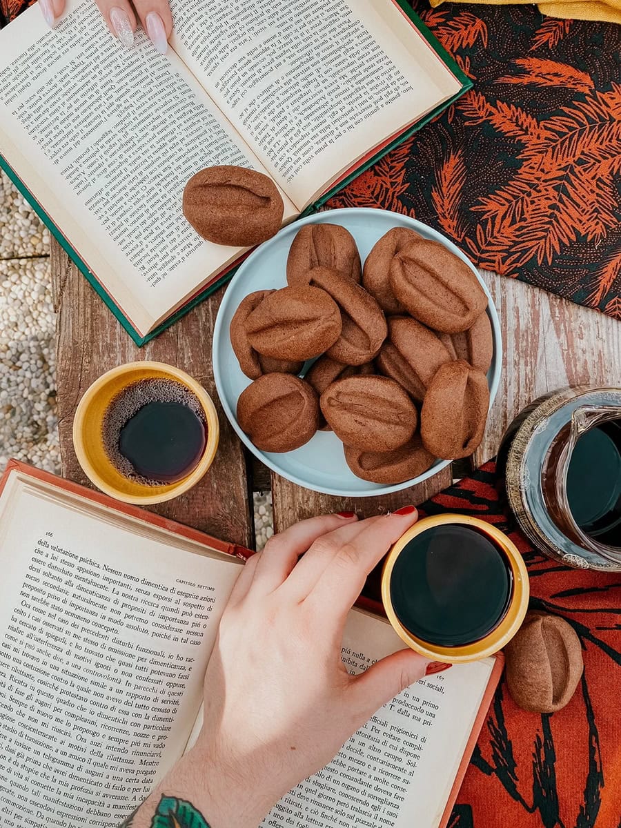 coffee bean cookies on a plate, two books on either side, more cookies around