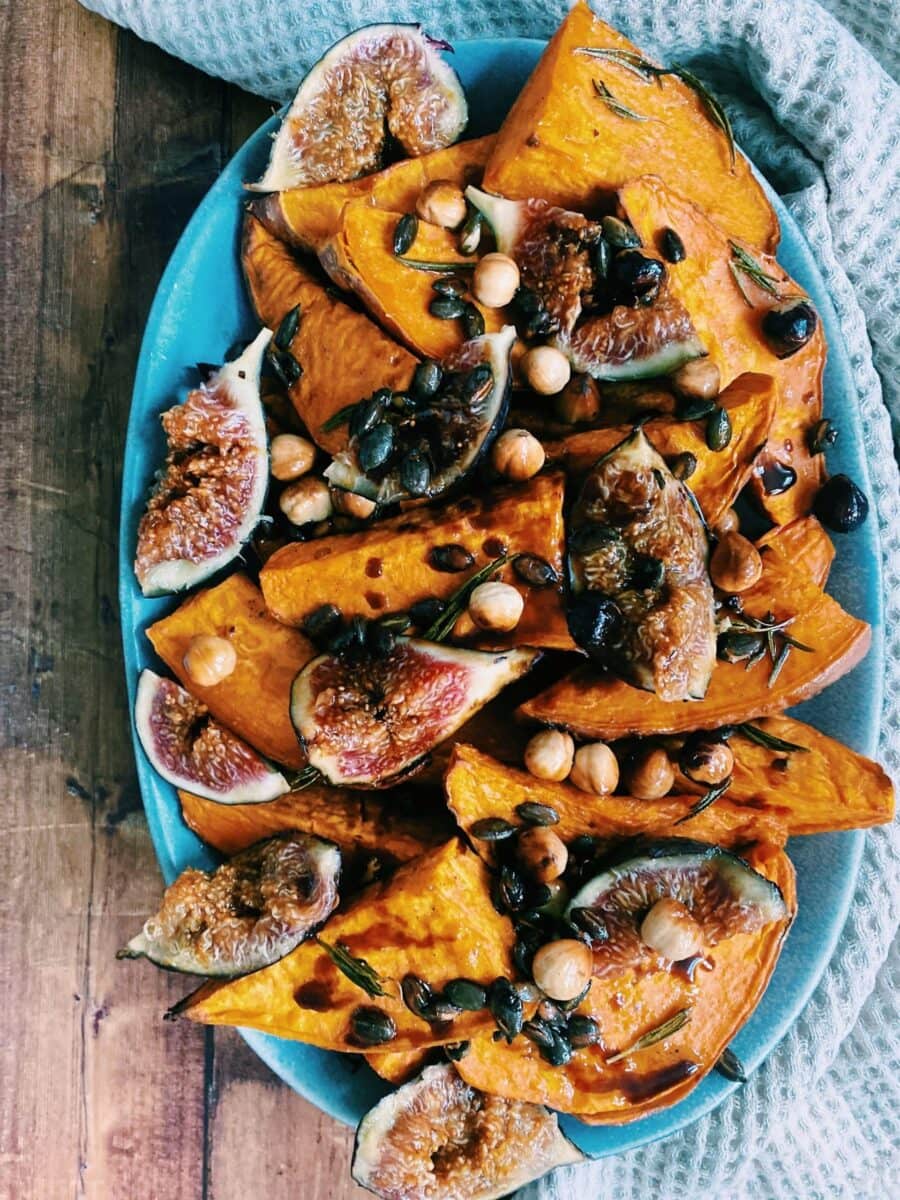 sweet potatoes, figs, hazelnuts and pumpkin seeds on a plate, a napkin under it
