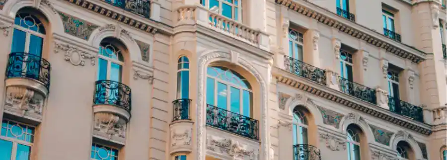Fachada clásica de edificio residencial con balcones de forja y ventanas simétricas
