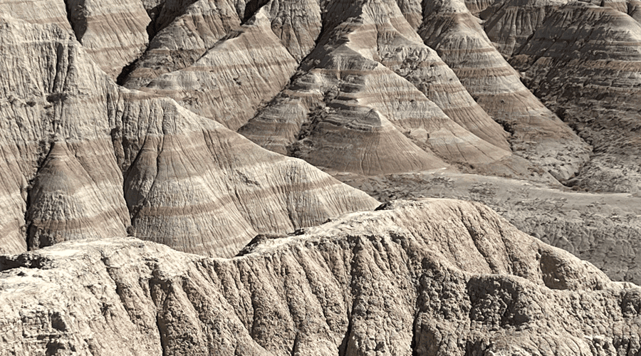 Badlands with multiple layers of rock stretch into the distance. taken on a Teton Excursions tour to Badlands National Park